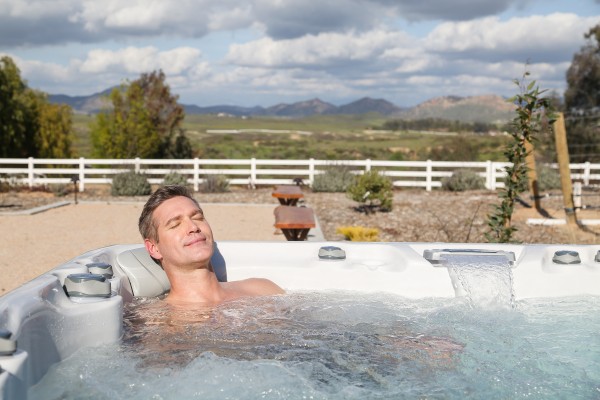 Man relaxing in an outdoor hot tub.