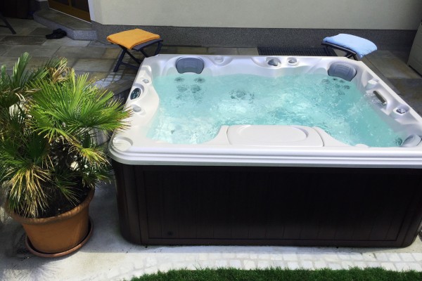 Outdoor hot tub installation on a patio in the spring.