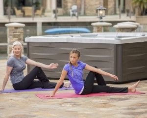 Yoga stretching in front of hot tub