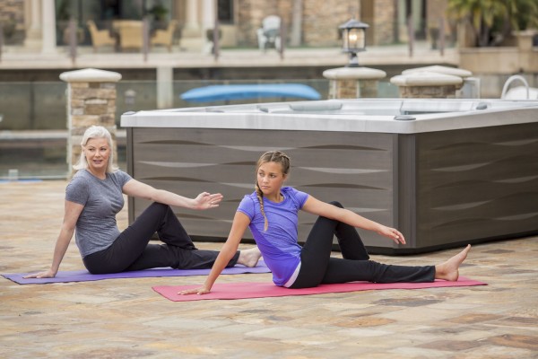 Yoga stretching in front of hot tub Yoga stretching in front of hot tub