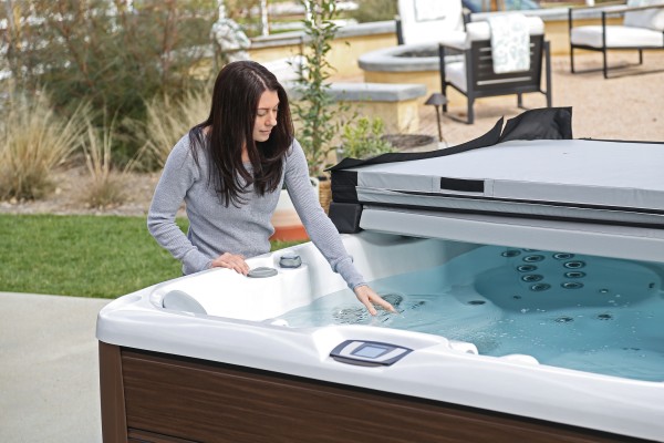Woman feeling the water in her hot tub.